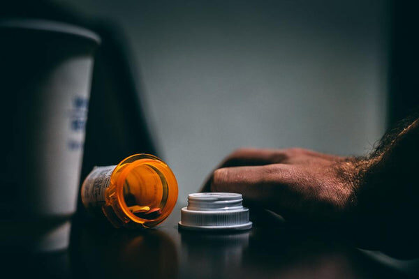 Immagini sintetizza vari tipi di farmaci tradizionali con una mano umano esausta di questa tipo di cura
